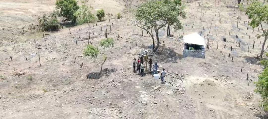 Aerial view of a work crew at a drill rig on a cleared exploration site