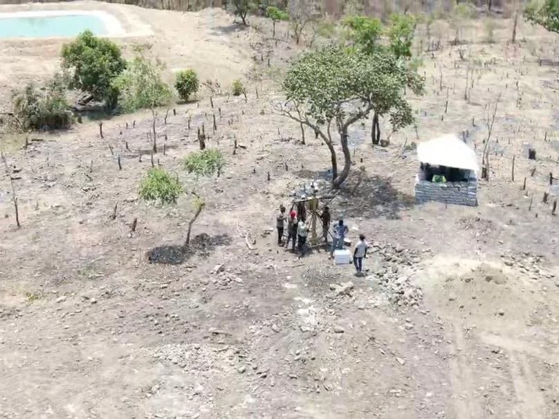 Aerial view of a work crew at a drill rig on a cleared exploration site