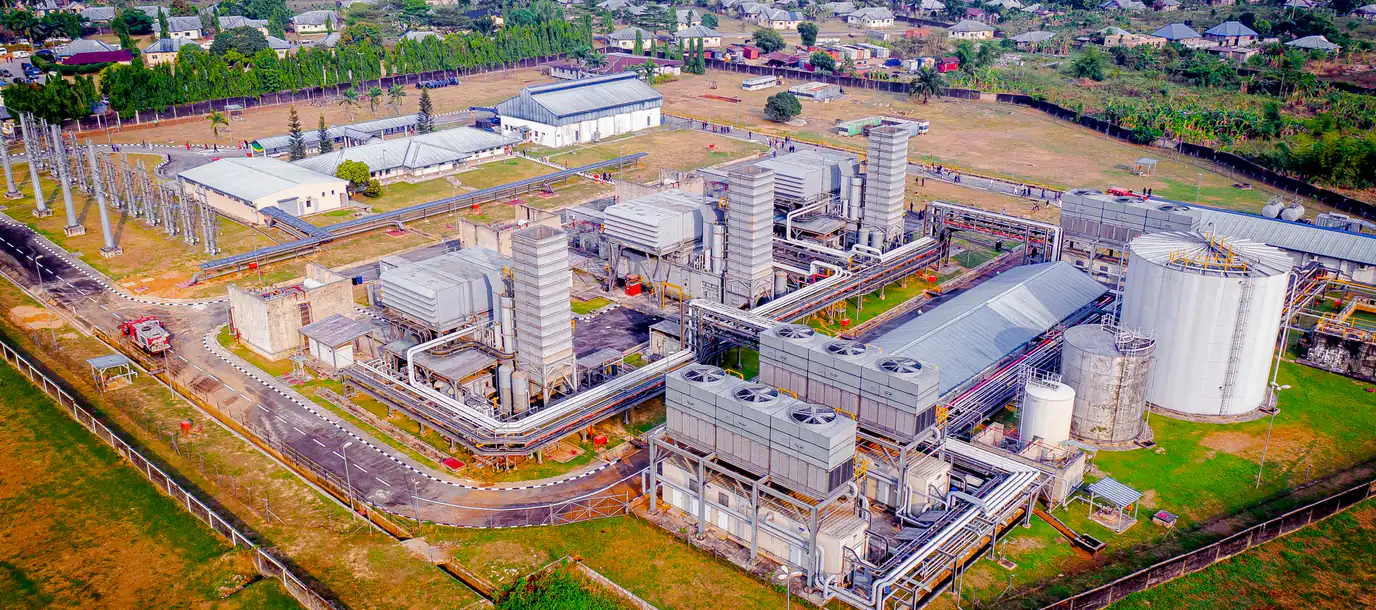 Aerial view of a gas-fired power plant and switchyard surrounded by residential housing
