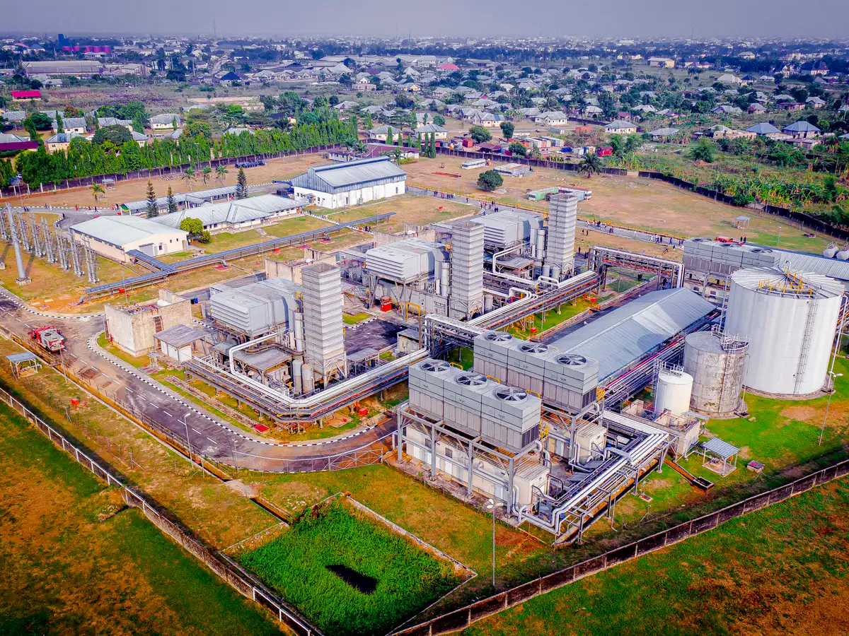 Aerial view of a gas-fired power plant and switchyard surrounded by residential housing